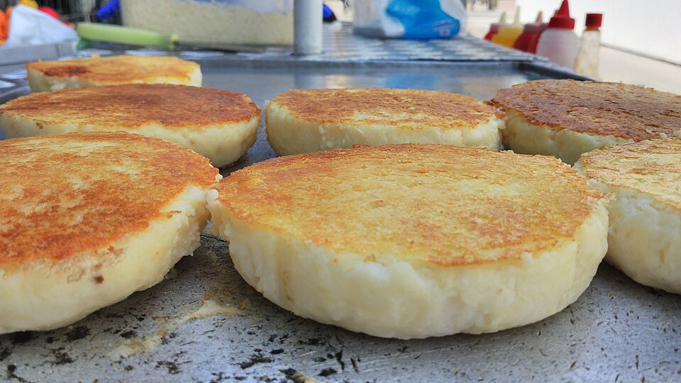 Arepas dorándose sobre una plancha en Cartagena